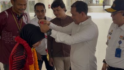 Wakil Ketua II KONI Sumbar, DR. Sepri mengalungi bunga untuk pegulat Sumbar yang meraih medali emas PON Beladiri