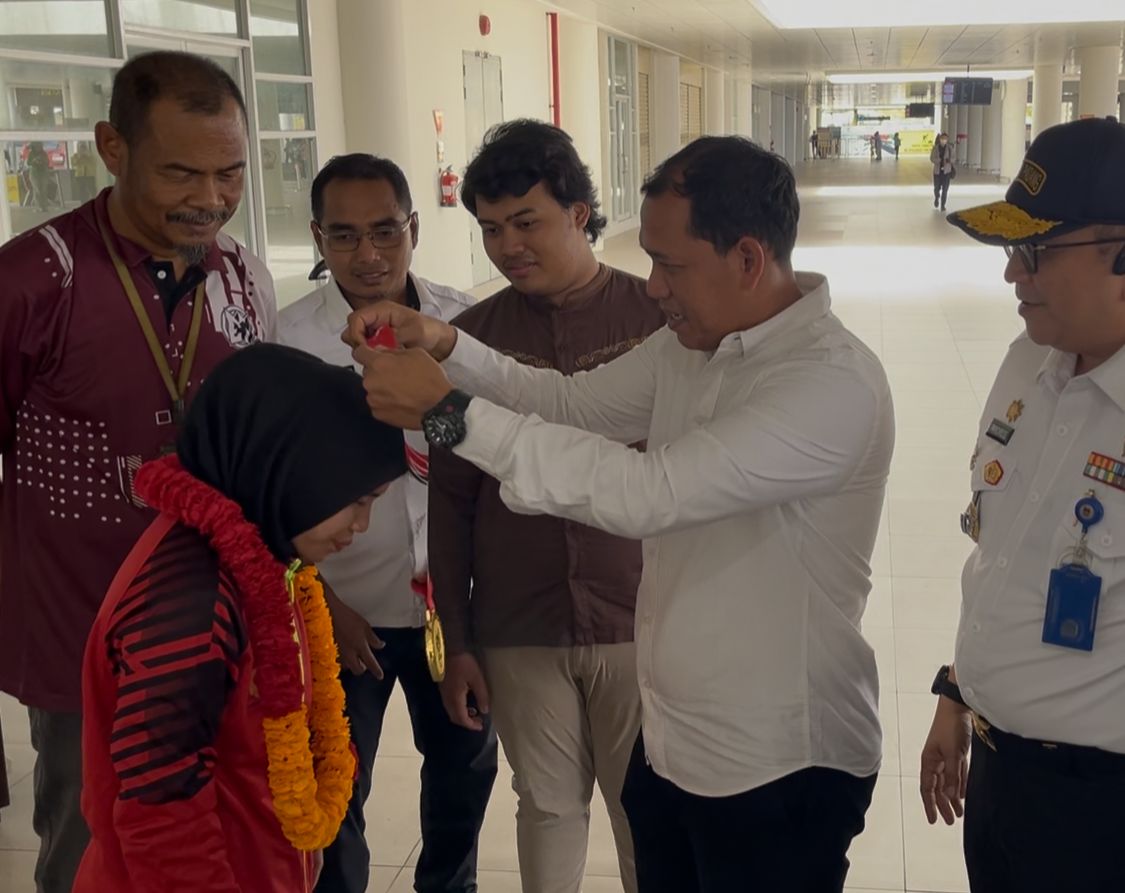 Wakil Ketua II KONI Sumbar, DR. Sepri mengalungi bunga untuk pegulat Sumbar yang meraih medali emas PON Beladiri